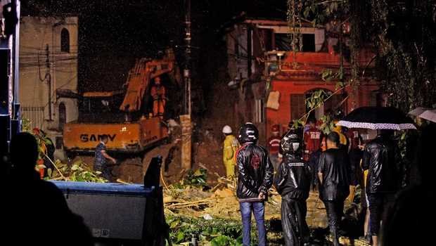 Rescue workers are seen at the site of a landslide in which a mother and six of her children were killed, in Paraty, Rio de Janeiro state, on April 2, 2022. - Torrential downpours triggered flash floods and landslides across Brazil's Rio de Janeiro state, killing at least 14 people including eight children, and leaving five missing, authorities said Saturday. (Photo by BRUNO KAIUCA / AFP)