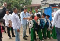 Foto saat H.Sobri memberikan makanan dan susu pada anak anak sekolah (DentumNews.com)